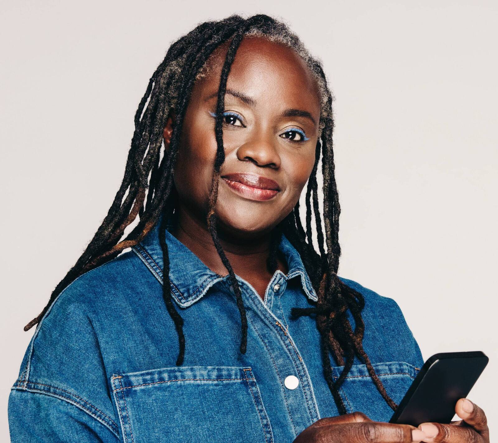 Woman smiling while holding her phone