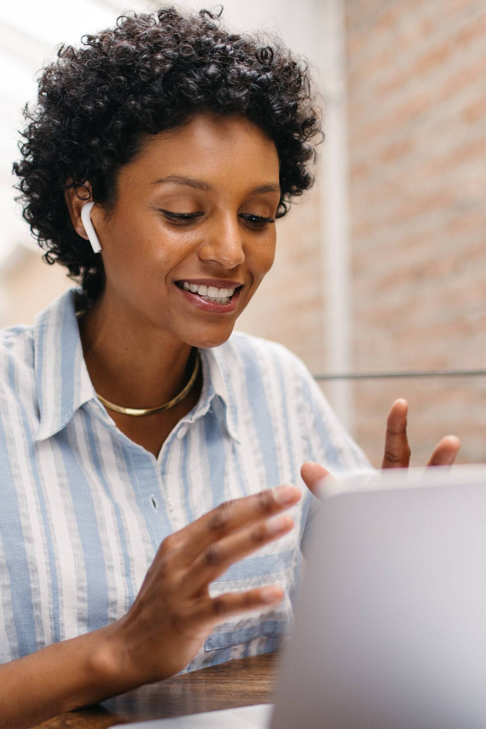 Woman wearing earbuds while on video call