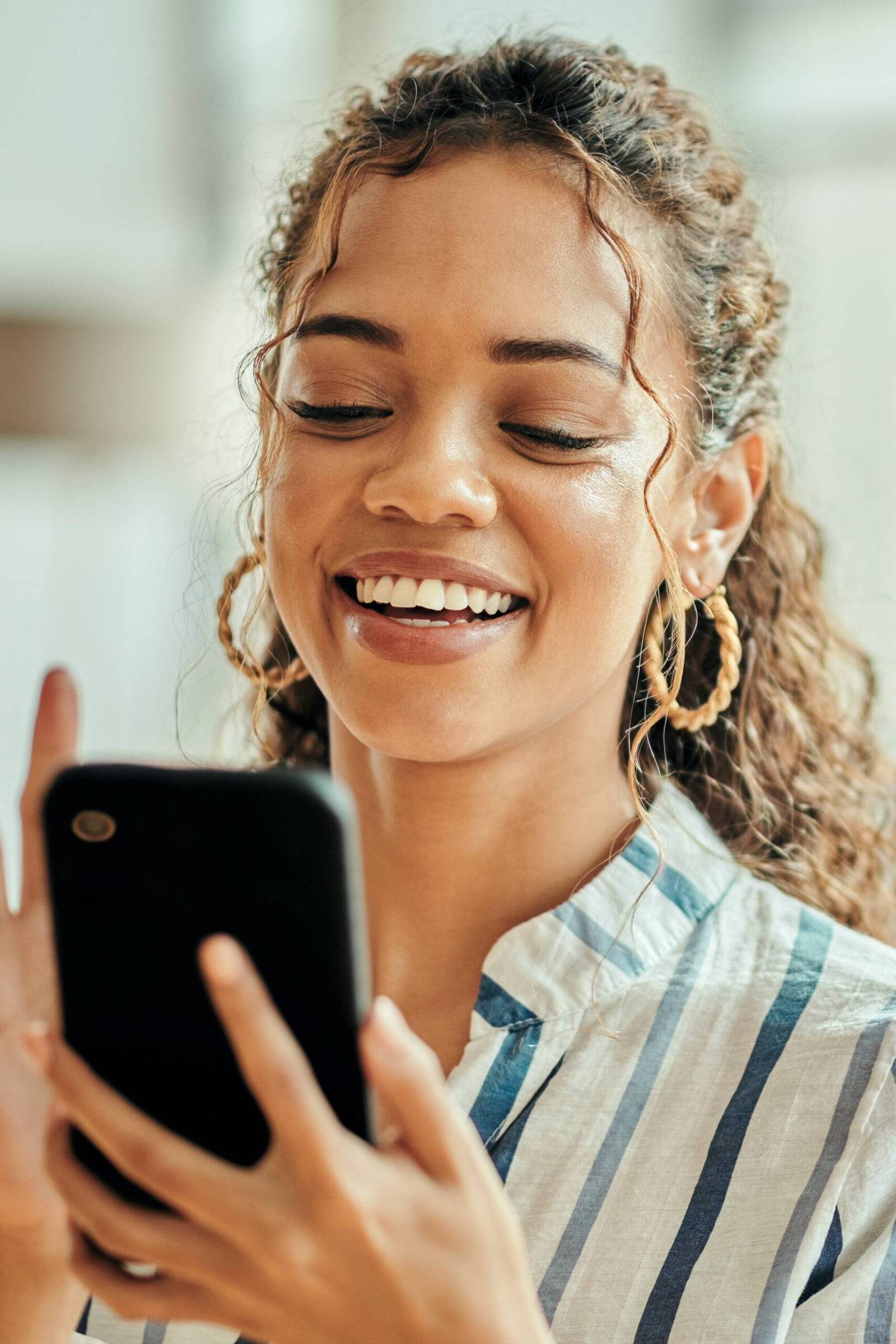 Woman smiling while using her phone